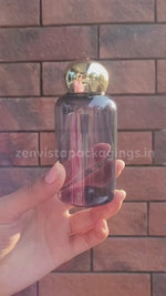 Load and play video in Gallery viewer, Transparent Black Color Pet Bottle With Gold Plated Dome Cap 100ml [ZMT110]
