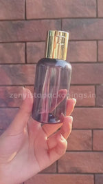 Load and play video in Gallery viewer, Transparent Black Color Pet Bottle With Gold Plated Fliptop Cap 100ml [ZMT100]
